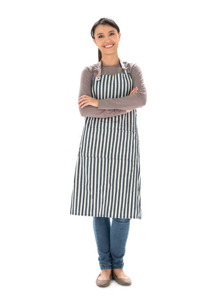 Fullbody shot of a happy waitress wearing an apron and smiling with arms crossed - isolated over a white background