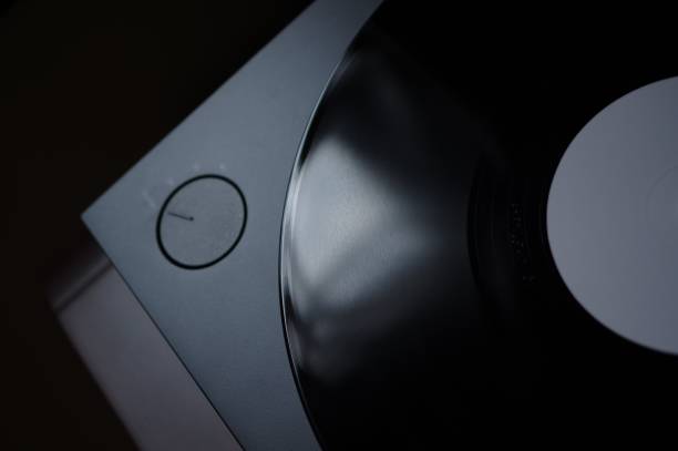 istock Grooves of tracks on vinyl record disc with white label spinning on modern turntable 1166757672