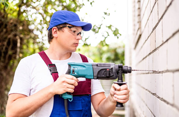 istock Construction worker in protection glasses and uniform with perforator drilling the wall outdoors. Man with drill 1166757982