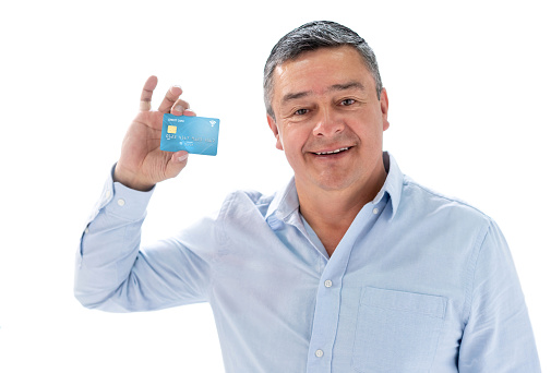 Portrait of a happy adult man holding a credit card and smiling in the studio -isolated over white. **DESIGN ON CARDS BELONG TO US**