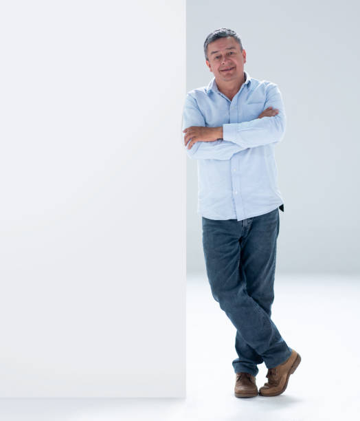 istock Man leaning against a wall and smiling 1166759555