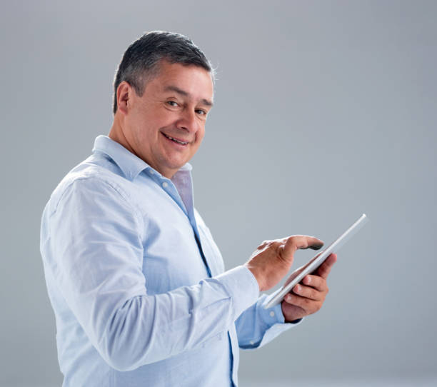 istock Adult man using app on a tablet computer and smiling 1166759564