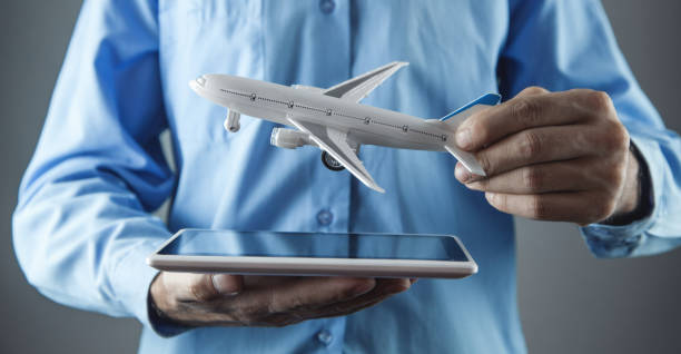 istock Man holding tablet with a toy airplane. Travel concept 1166759968