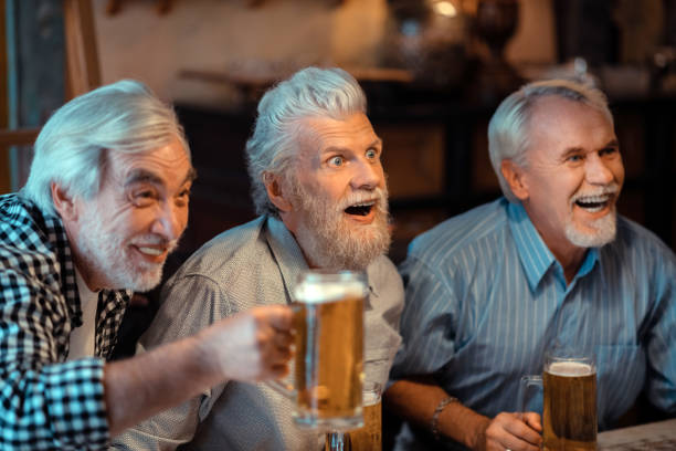 istock Three pensioners laughing while watching football in pub 1166760592