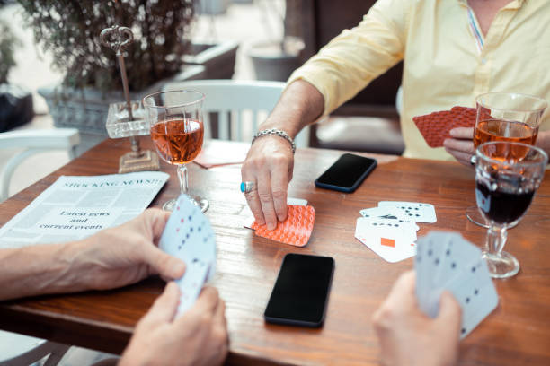 istock Man taking cards while gambling with old friends 1166760941