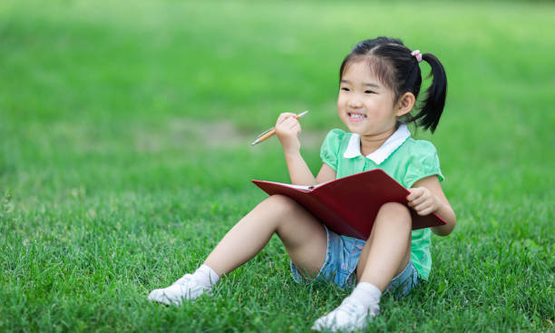 istock Cute little girl learning on the lawn 1166761230