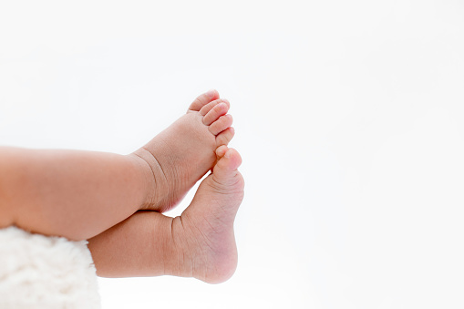 Close up baby feet against white background