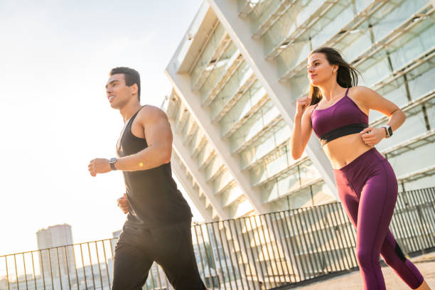 istock Beautiful couple in motion running over bridge 1166768231