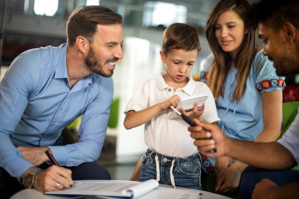 istock Father signing documents while his little boy plays with a calculator 1166769412