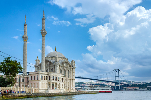 Istanbul landscape. Istanbul's popular touristic destination Ortakoy Mosque and Bosphorus Bridge view. Cloudy sky in summer day