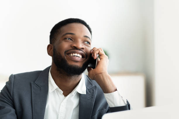 istock Glad african businessman talking on cellphone at office 1166773194