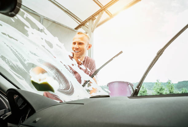 istock Inside the car camera view of Man washes his car windshield window 1166773241