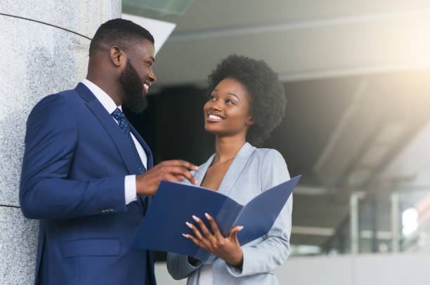 A couple of business partners smiling and making eye contact Happy of working together. A couple of young african american business partners smiling and making eye contact. Copy space african american business couple stock pictures, royalty-free photos & images