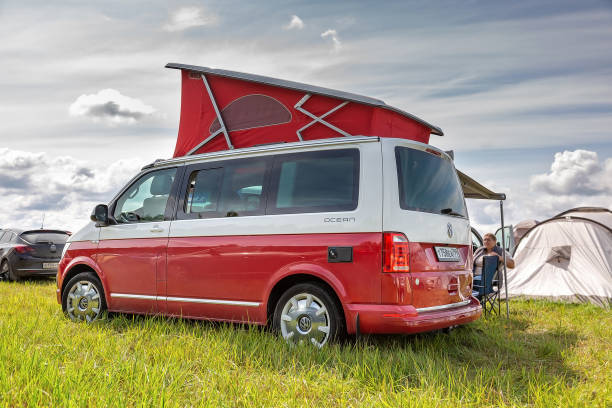 rosso e bianco colorato moderno volkswagen multivan california ocean (transporter t6). parcheggiato sul campo da campeggio. vista posteriore sinistra - left field foto e immagini stock