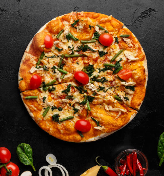 istock Hot pizza decorated with tomatoes and herbs, top view 1166773860