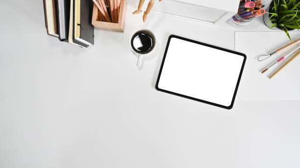istock Mockup tablet, coffee and office supply on white office desk with top view. 1166773926