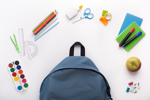 Set of stationery ready to be inside backpack before school on white background