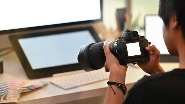 istock Photographer workplace Shot of photographer using professional camera and blank screen display. 1166774067