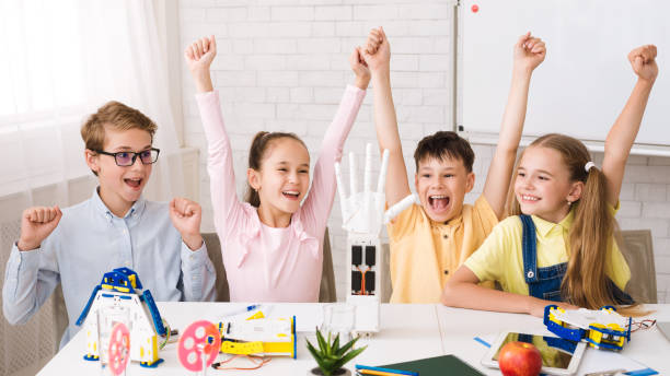 istock Stem education. Children raising hands after doing robots 1166775750