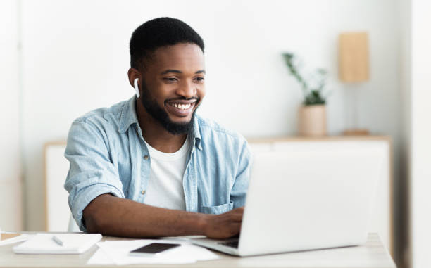 Smiling african-american guy in earphones studying foreign language online Smiling african-american guy in earphones studying foreign language online through video conference application, panorama with copy space e learning photos stock pictures, royalty-free photos & images