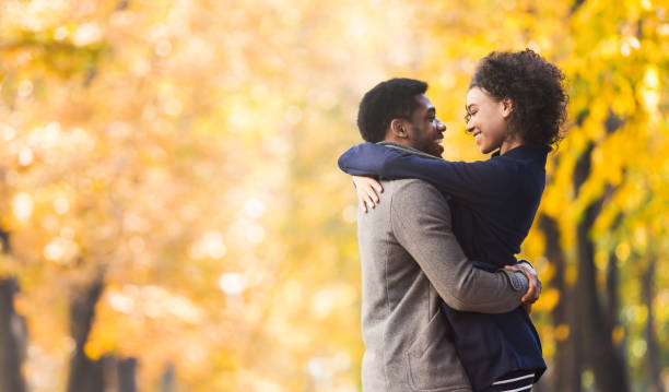 Loving couple hugging and looking into each other eyes Loving couple hugging and looking into each other eyes in autumn city park, copy space female likeness photos stock pictures, royalty-free photos & images