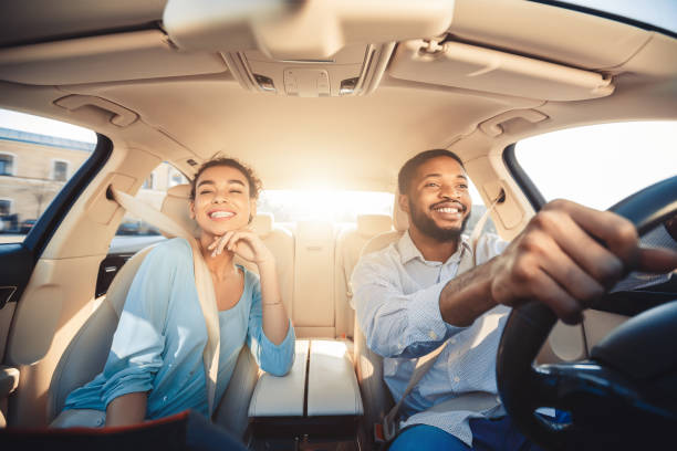 Enjoying travel. Excited african couple driving car Enjoying travel. Excited african couple driving car and smiling, copy space showroom photos stock pictures, royalty-free photos & images