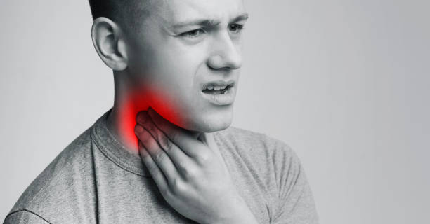 istock Man suffering with sore throat, touching his neck with hand 1166777531