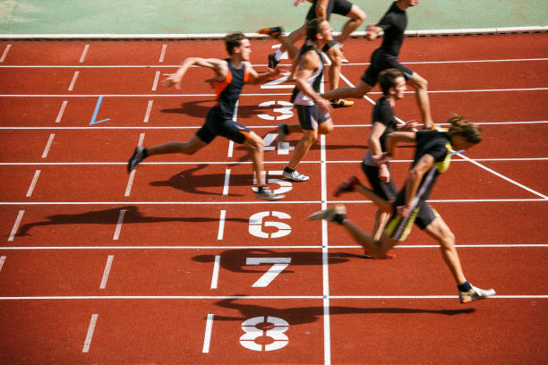 Athlets sprinting at finish line Sprint competition on running track. Finish line low angle view. mens track stock pictures, royalty-free photos & images