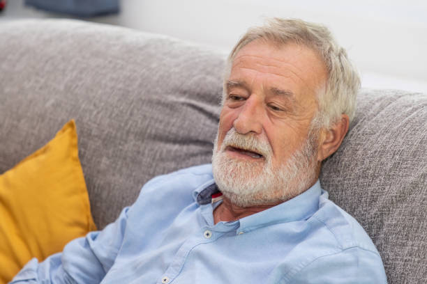 istock Relax happy senior old man eldery sitting on comfortable sofa in living room 1166777947