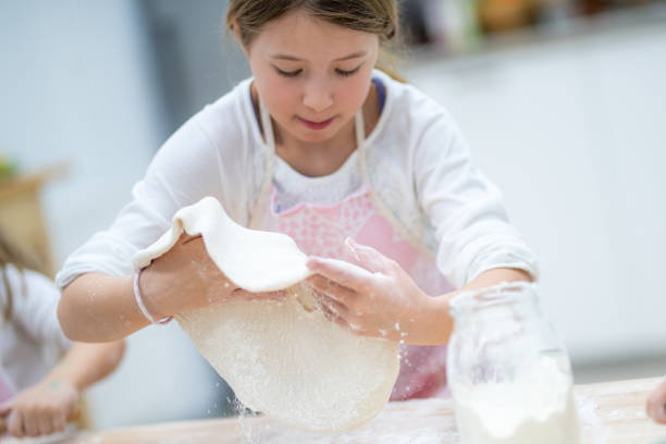 istock Girl making pizza in cooking class 1166780525