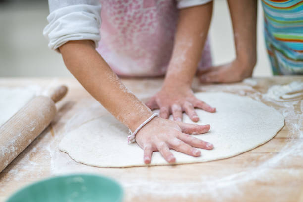 Close-up of children making pizza in cooking class stock photo