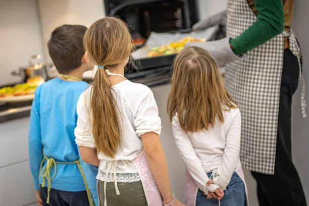 frau backt pizza im ofen - school classroom child back to school stock-fotos und bilder