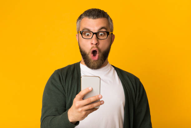 Shocked handsome man looking at his cellphone