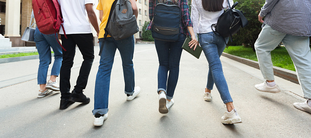 Unrecognizable teenage students in high school campus walking at break, crop