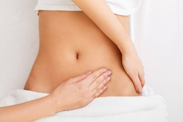 mujer joven con masaje estomacal en el centro de spa - pampering massaging indoors adult fotografías e imágenes de stock