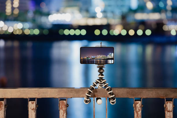 Using smartphone on flexible tripod to making the photo of city night lights stock photo