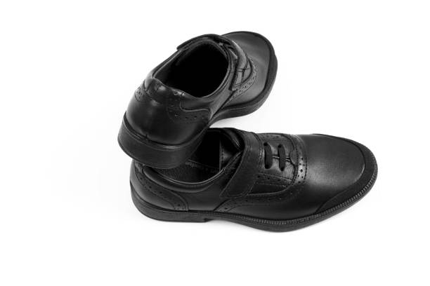 istock black children’s leather shoes with a white background, isolate 1166785314