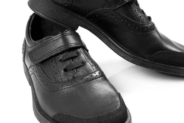 istock black children’s leather shoes with a white background, isolate 1166785342