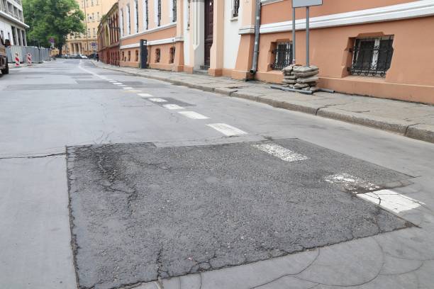 City street damage Damaged city street - cracks and patches on blacktop. Wroclaw, Poland. low photos stock pictures, royalty-free photos & images