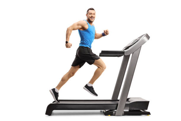 junger mann in sportbekleidung läuft auf einem laufband und schaut in die kamera - treadmill gym isolated running stock-fotos und bilder