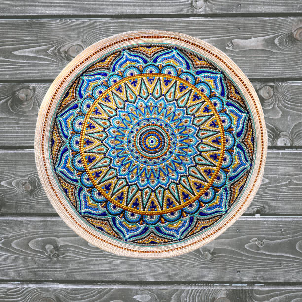 istock Decorative ceramic plate, hand painted dot pattern with acrylic paints on a gray wooden background. A square photo. Closeup. 1166792324