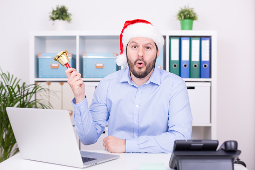 Attractive man is ringing the bell at christmas time. Business, christmas and new year celebration concept.