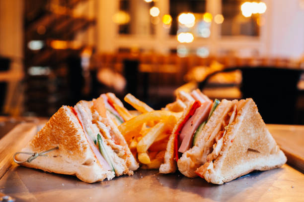 Club sandwich with french fries big club sandwich on skewer with ham, cucumber, cheese, tomato, chicken, served with French fries sandwich club sandwich lunch restaurant stock pictures, royalty-free photos & images