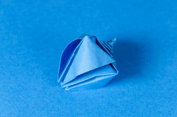 istock Blue origami seashell on blue background 1166798472