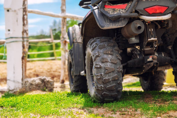 ATV quad bike vehicle standing near wooden fence at farm or horse stable. Back view of all wheel drive motorcycle at farm. Rural countryside machine ATV quad bike vehicle standing near wooden fence at farm or horse stable. Back view of all wheel drive motorcycle at farm. Rural countryside machine. quadbike photos stock pictures, royalty-free photos & images