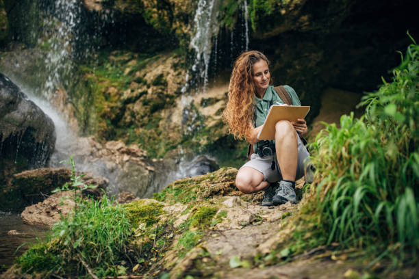 istock Woman biologist taking notes in nature by the waterfall 1166802653
