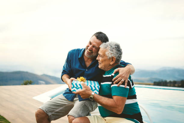 Son giving a gift for his father on father's day. Son and his father on the father's day fathers day stock pictures, royalty-free photos & images