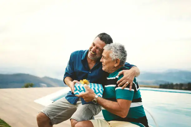 Photo of Son giving a gift for his father on father's day.