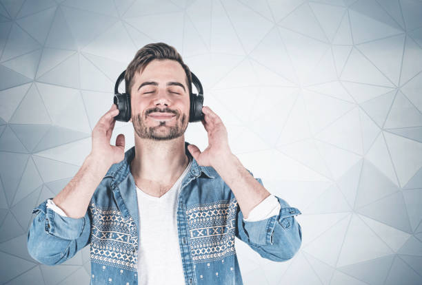 istock Smiling man listening to music, wall 1166803452