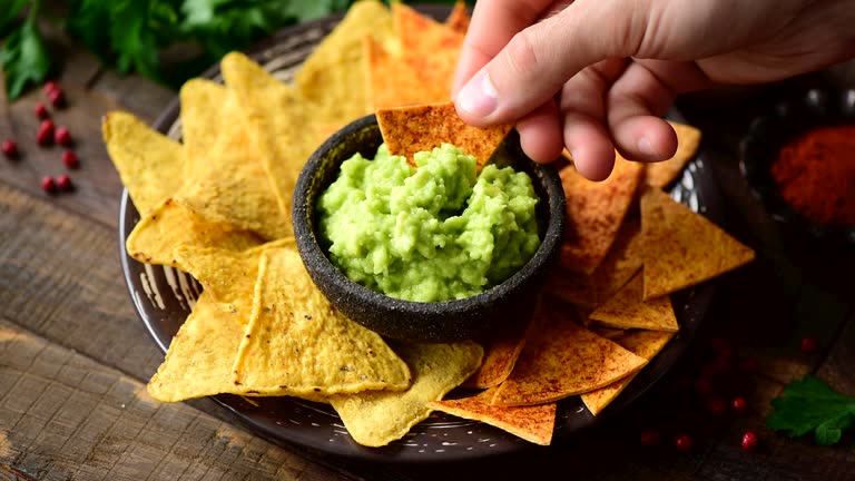 Eating corn chips nachos with guacamole